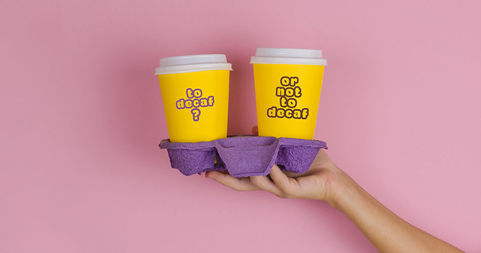 paper_decaf_coffee_or_regular_cups_on _pink_background_thestoryofcoffee